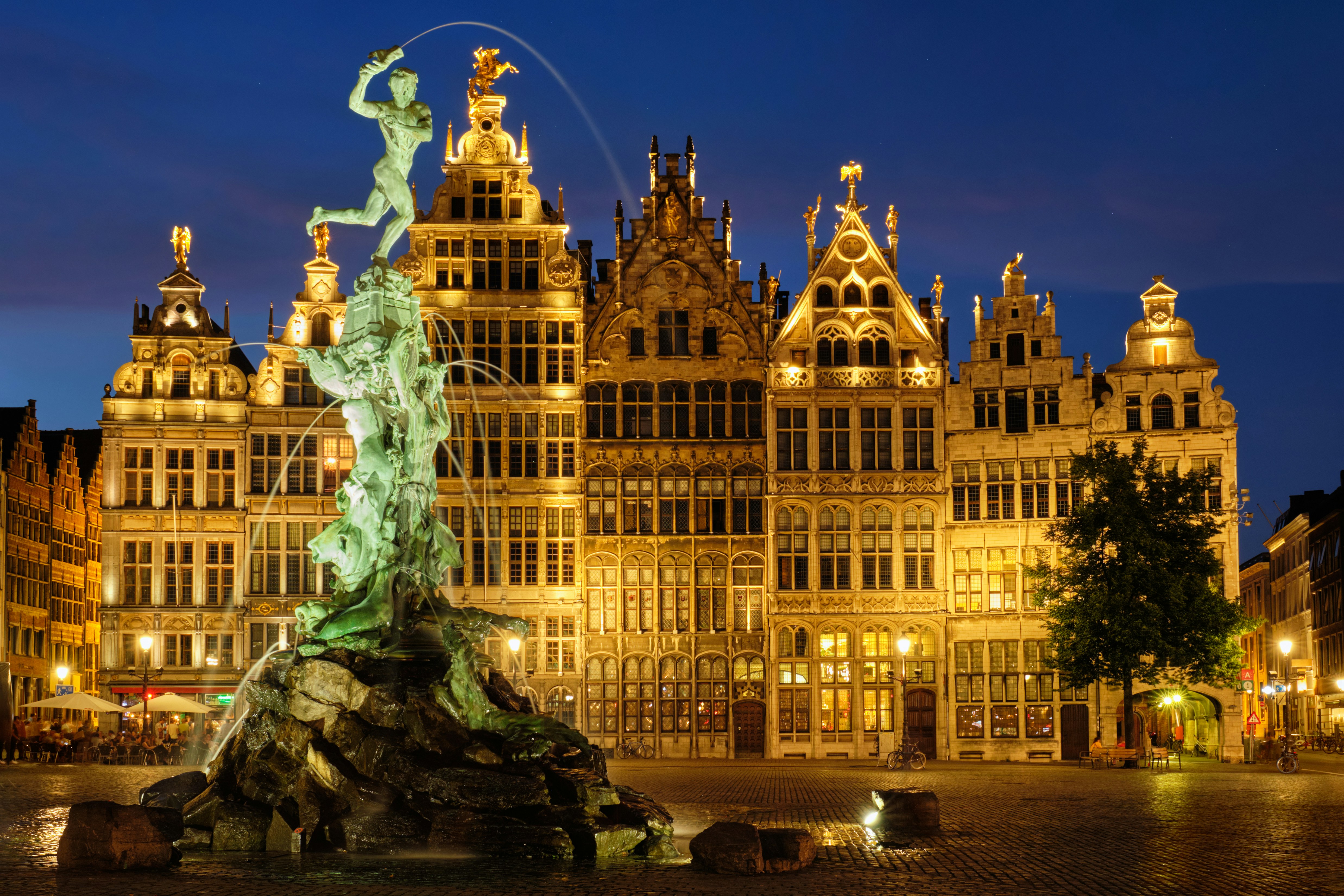 Antwerpens Grote Markt bei Nacht mit Brabo-Brunnen und Gildehäusern